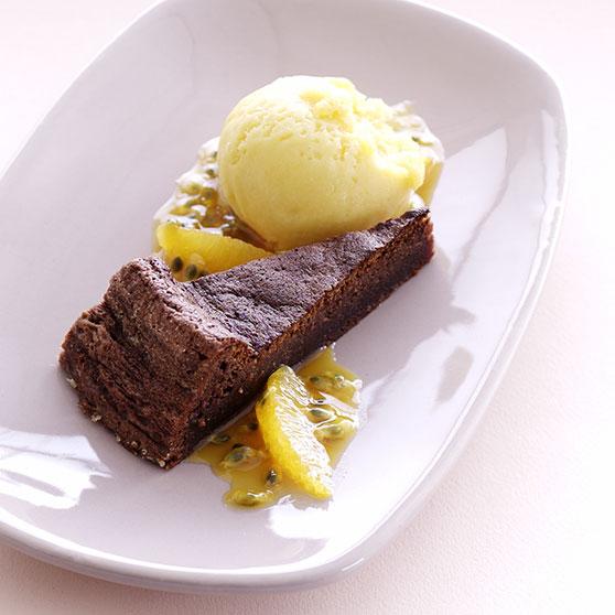 Orange chocolate cake with orange sherbet and passion fruit sauce